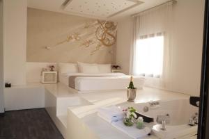 ein weißes Schlafzimmer mit einem Bett und einem Waschbecken in der Unterkunft Aleph Boutique Hotel in Byblos