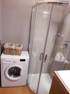 een badkamer met een wasmachine en een douche bij Apartament Jelen'iowska in Kielce