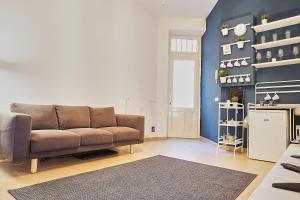 sala de estar con sofá y pared azul en ONYX Apartment, en Budapest