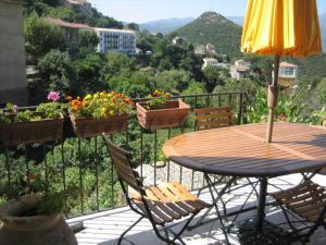 - une terrasse avec une table, des chaises et des fleurs dans l'établissement Casa Laurina, à Oletta