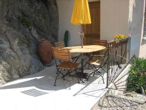 d'une table, de chaises et d'un parasol jaune sur le balcon. dans l'établissement Casa Laurina, à Oletta