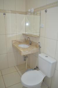 ein Badezimmer mit weißer Toilette und Waschbecken in der Unterkunft Hotel Samambaia in Indiara  + 45 Fotos