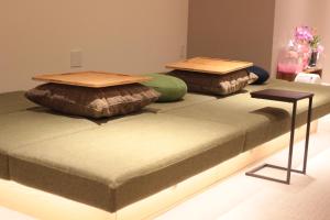 a bed with two pillows on top of it at Guesthouse COCO Hiroshima (Female Only) in Hiroshima