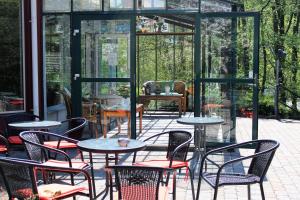 a patio with tables and chairs in a glass house at Place Lund Studios in Lund