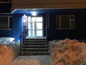uma escada que leva a uma porta com um monte de neve em Hostel Ovsyanka em Yuzhno-Sakhalinsk