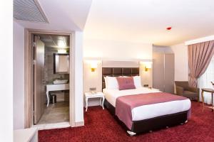 a hotel room with a bed and a bathroom at Perla Arya Hotel in Izmir