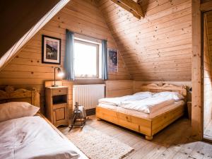 een slaapkamer met 2 bedden in een houten huis bij TatryTop Domek pod Giewontem in Zakopane