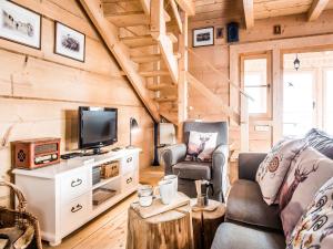 een woonkamer met een bank en een tv bij TatryTop Domek pod Giewontem in Zakopane