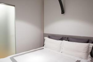 ミラノにあるMilano Repubblica Suite Centroのベッド(白いシーツ、枕付)