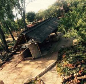 a small house with a roof on top of it at Damascus Bush Lodge in Hartbeespoort