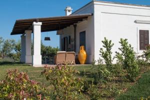 a white house with a large vase on the porch at Villa del Vento in Polignano a Mare