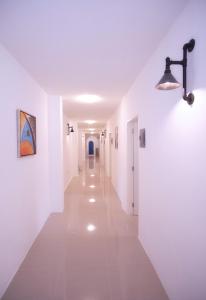 un couloir blanc avec des murs blancs et un plafond dans l'établissement D´Gecko Hotel, à Moalboal