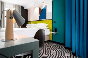 a room with a bed and a desk and a lamp at Hotel Pilime in Paris +37 photos