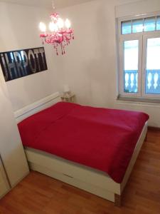 1 dormitorio con 1 cama grande de color rojo y lámpara de araña en Ruhrdomizil, en Essen