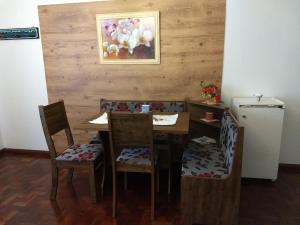 a dining room with a table and chairs and a painting at Hospedaria da Cecília Moser in Treze Tílias
