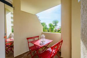 d'une petite table rouge et de chaises sur un balcon. dans l'établissement Cubo's Estudio 118 Benal Beach, à Benalmádena