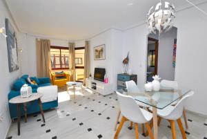 sala de estar con mesa de cristal y sillas blancas en Cubo's Apartamento B1 2A Lubina del Sol, en Mijas Costa