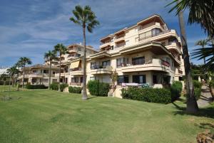 un gran edificio de apartamentos con palmeras y un patio en Cubo's Apartamento B1 2A Lubina del Sol, en Mijas Costa