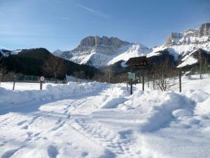 une route recouverte de neige avec des montagnes en arrière-plan dans l'établissement Auberge Buissonniere, à Gresse-en-Vercors