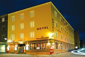 ein großes gelbes Gebäude mit einem Hotel in einer Straße in der Unterkunft StadtHotel Passau in Passau