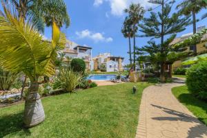 un jardín con una palmera y una piscina en Cubo's Beach & Golf Marbella, en Marbella