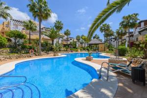 una piscina en un complejo con palmeras en Cubo's Beach & Golf Marbella, en Marbella