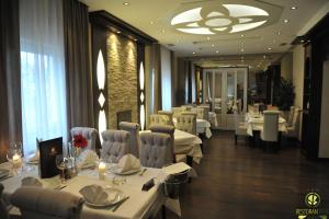 a restaurant with white tables and chairs and a large window at B&B Park in Sremčica