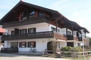 a large white building with a wooden roof at Ferienwohnung "Unterberg" in Reit im Winkl