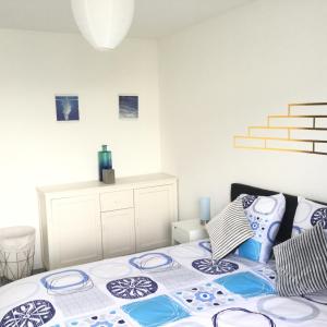 a bedroom with a bed with blue and white pillows at SouheilRebekaHome in Serris