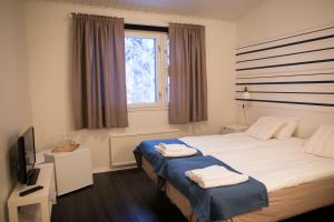 a bedroom with a bed with two towels on it at Kuerkievari KuerHotel in Äkäslompolo