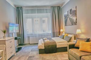 a bedroom with a bed and a couch and a window at K1 Budapest | Apartment in Budapest