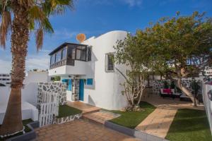 a white house with palm trees in front of it at Palm Villa in Puerto del Carmen