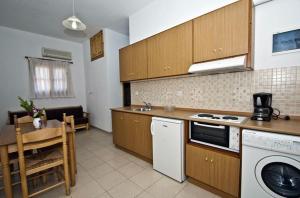 ネオ・キリマにあるAthina Apartmentsのキッチン(コンロ、食器洗い機、テーブル付)
