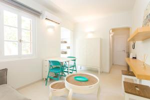 a white living room with a table and chairs at Casa Cozy in M&yacute;konos City