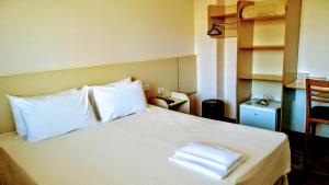 Un pat sau paturi într-o cameră la Vespasiano Hotel Telêmaco Borba