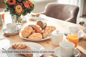 a table with a plate of breakfast bread and orange juice at Private Holiday Homes by Solaria in Davos