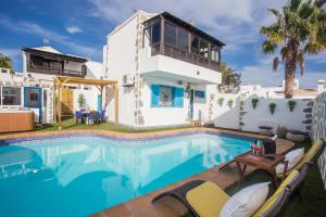 a swimming pool in front of a house at Palm Villa in Puerto del Carmen