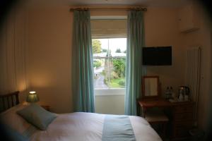 a bedroom with a bed and a large window at Craig Y Glyn in Pwllheli