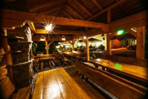 an outdoor restaurant with wooden benches and tables at Cubus-Beskidy in Bierna