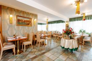 a restaurant with tables and chairs and a painting on the wall at Jagodic Garni Hotel in Cerklje na Gorenjskem