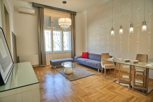 a living room with a blue couch and a table at Basilica Royal Apartment | Budapest in Budapest