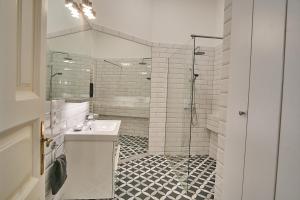a white bathroom with a sink and a shower at Basilica Royal Apartment | Budapest in Budapest +11 photos