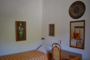a bedroom with a bed and a clock on the wall at Epavlis Iosif in Hora Sfakion