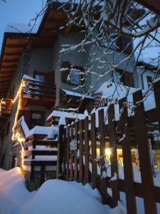 a fence covered in snow in front of a house at Euroski B&B in Aosta