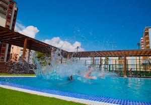 een persoon die speelt in een fontein in een zwembad bij Ag Bermudas Premium in Gandía
