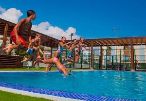 a group of people jumping into a swimming pool at Ag Bermudas Premium in Gandía