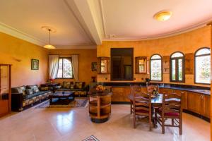 een woonkamer met een bank en een tafel bij Villa Zahra Palmeraie in Marrakesh