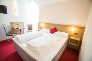 a bedroom with a large white bed with a red carpet at Weingut Blank in Homburg