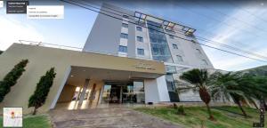a building with a palm tree in front of it at Portinari Palace Hotel in Vilhena +15 photos