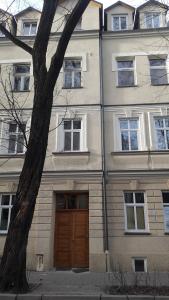 a building with a wooden door and a tree at Jacuzzi Apartment Red in Krakow